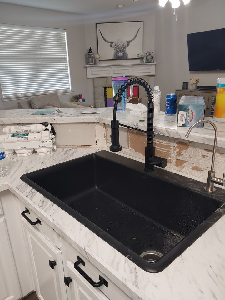 A kitchen sink with a black faucet in it