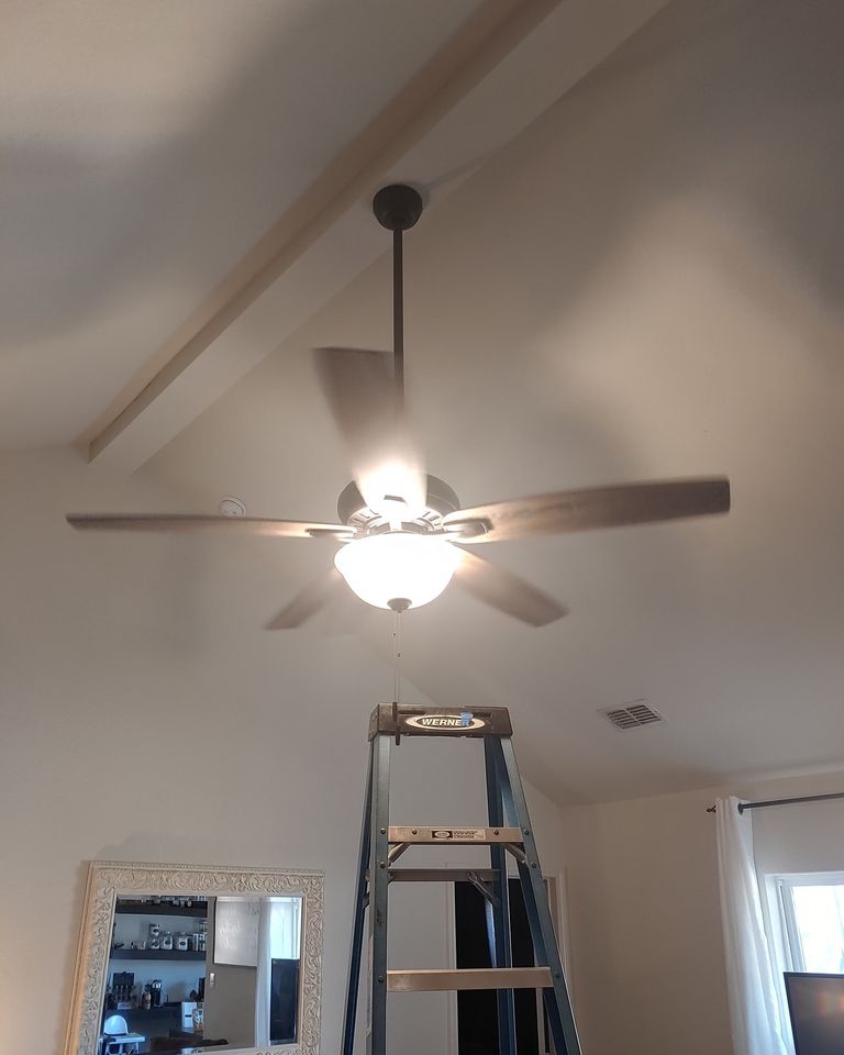 A room with a ladder and a ceiling fan